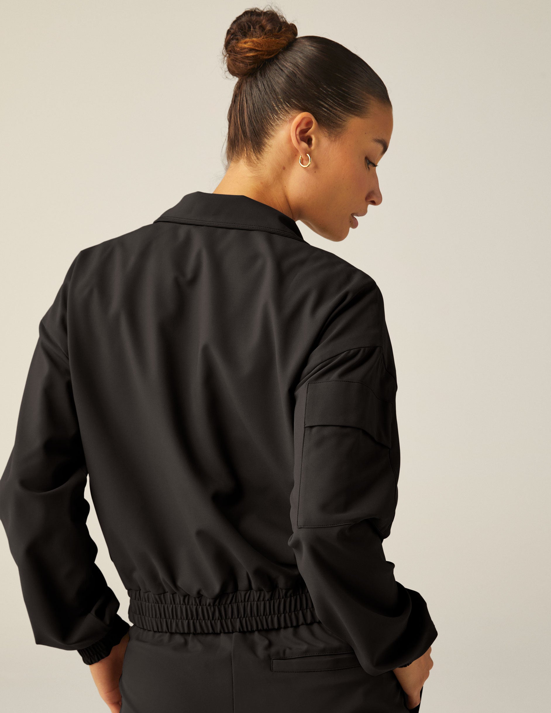 black zip-up jetstretch woven jacket with a collar. 