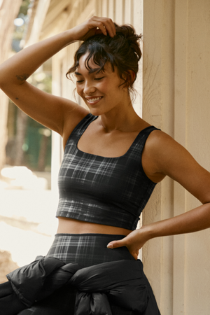 Woman wearing a plaid cropped tank and leggings outdoors. 