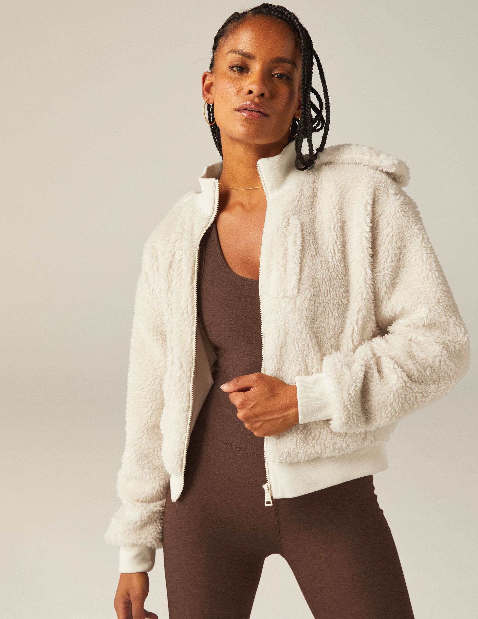 white zip-up hooded faux sherpa jacket with pockets.