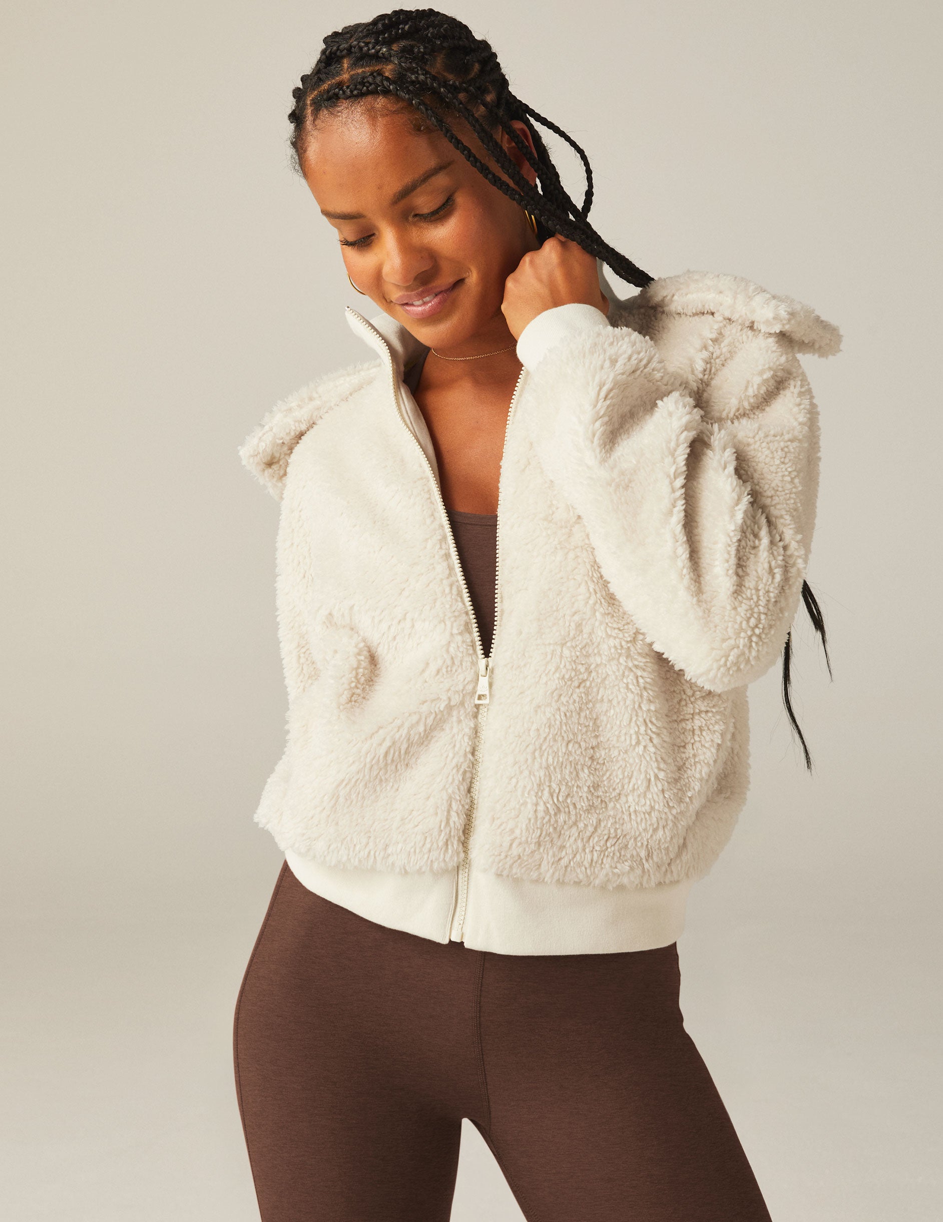 white zip-up hooded faux sherpa jacket with pockets.