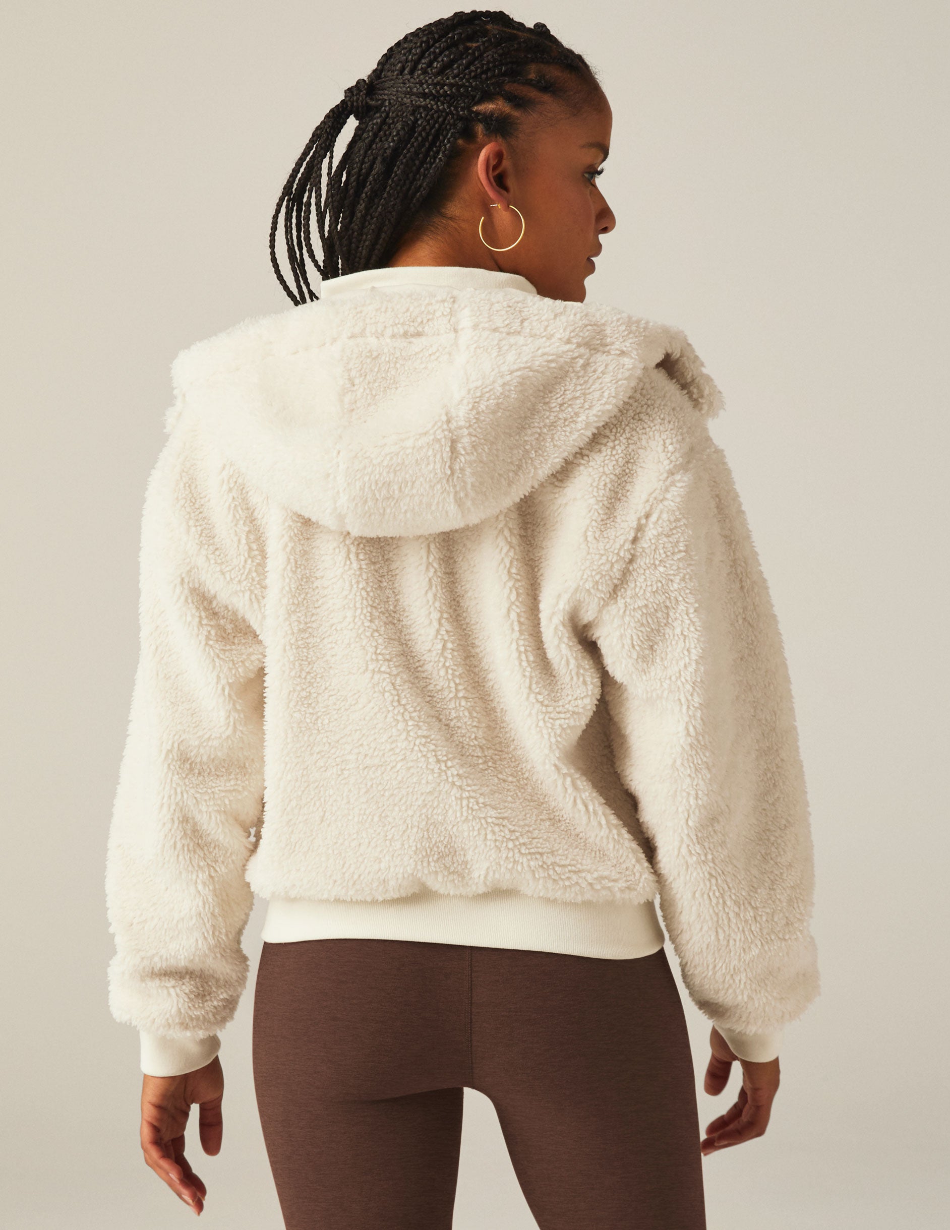 white zip-up hooded faux sherpa jacket with pockets.