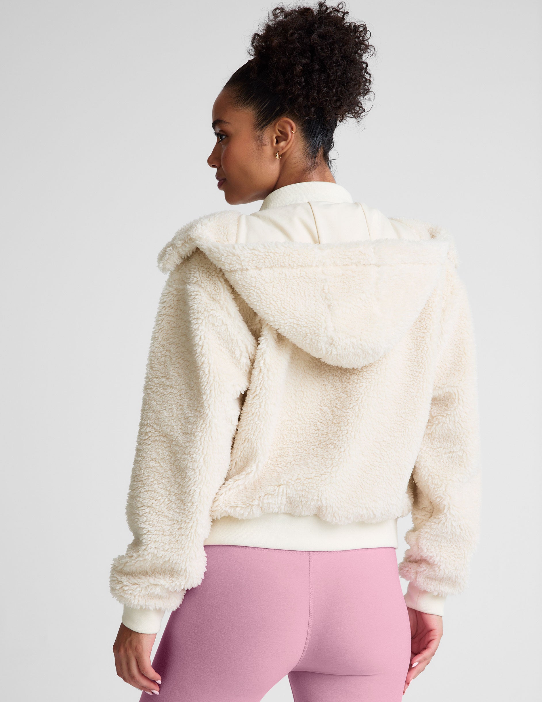 white zip-up hooded faux sherpa jacket with pockets.