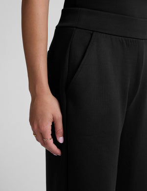 Close-up of black In The Flow Wide Leg Pant showing the smooth elastic waistband and front slant pocket on a model.