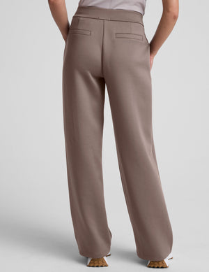 model is wearing brown spacer style pants with pockets against a plain background. 