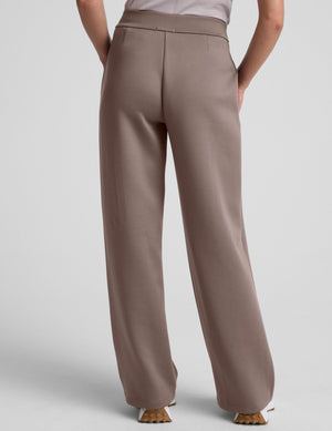model is wearing brown spacer style pants with pockets against a plain background. 