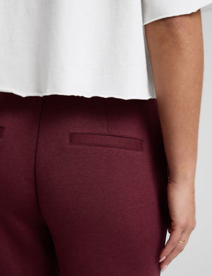 Close-up back view of the maroon SoftSpring Tapered Pant highlighting the welt pocket and smooth fabric texture.
