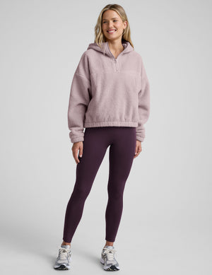 Woman wearing a pink quarter zip fleece pullover against a plain background. 