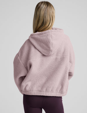 Woman wearing a pink quarter zip fleece pullover against a plain background. 