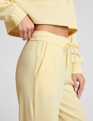 Yellow ribbed sweater and pants set on a light gray background. 