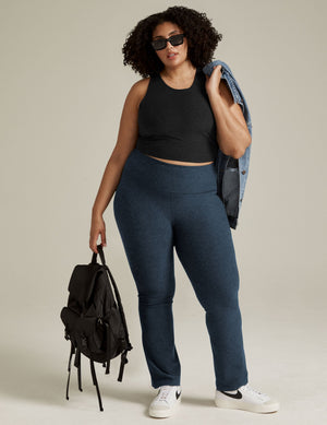 Navy Spacedye Practice High Waisted Pant featuring a marled texture and bootcut leg on a model with a backpack.