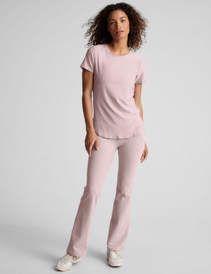 model wearing pale pink bootcut pants against a plain background. 