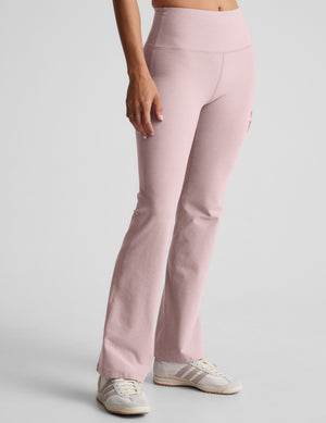 model wearing pale pink bootcut pants against a plain background. 