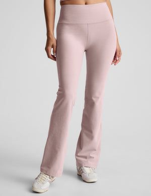 model wearing pale pink bootcut pants against a plain background. 
