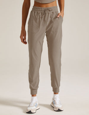 Woman wearing Gray Spacedye Commuter Midi Jogger™ with slant pockets and drawstring, paired with white socks and sneakers.