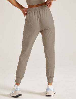 Rear view of woman wearing Gray Spacedye Commuter Midi Jogger™ with a matching crop top and white sneakers.