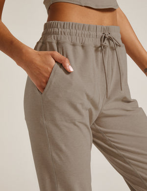 Woman wearing Gray Spacedye Commuter Midi Jogger™ with hand in slant pocket, paired with a matching crop top.