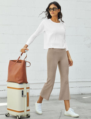 Woman in beige marled Spacedye Retro Cropped Pant, white top, and sneakers, standing with a suitcase and leather tote bag.