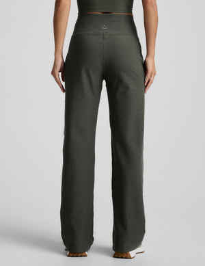 Back image of green wide leg pants with pockets on a plain background. 