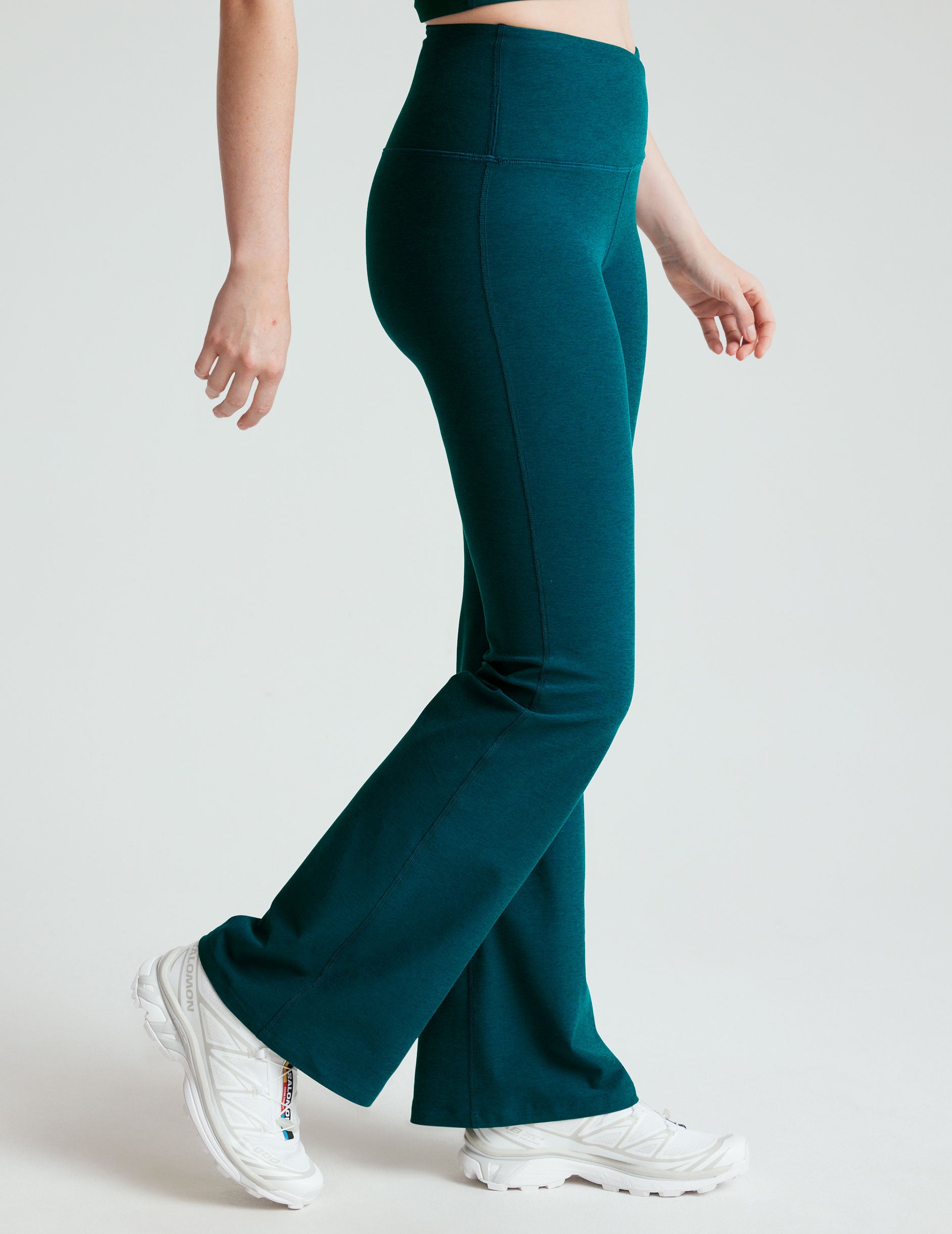 blue high-waisted bootcut pants with a front crossover detail on the waistband. 