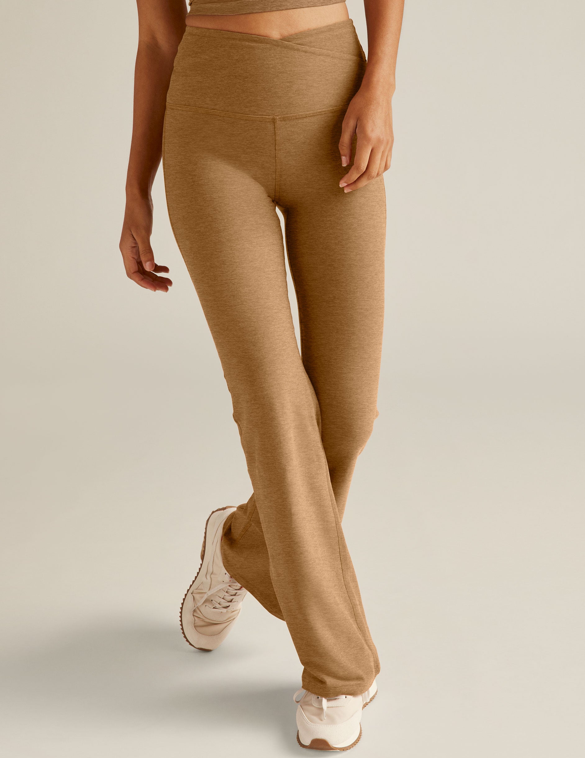 brown high-waisted flare leggings with a crossover detailing on the front waistband. 