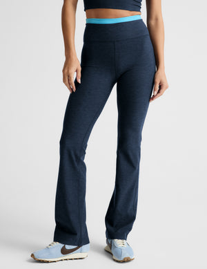 Woman wearing a navy athletic outfit with a white background. 