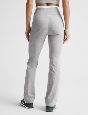 Woman wearing a gray layered bra and gray layered pants against a plain background. 