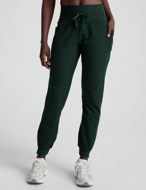 model wearing green midi length joggers with a drawcord at the waistband against a plain background. 