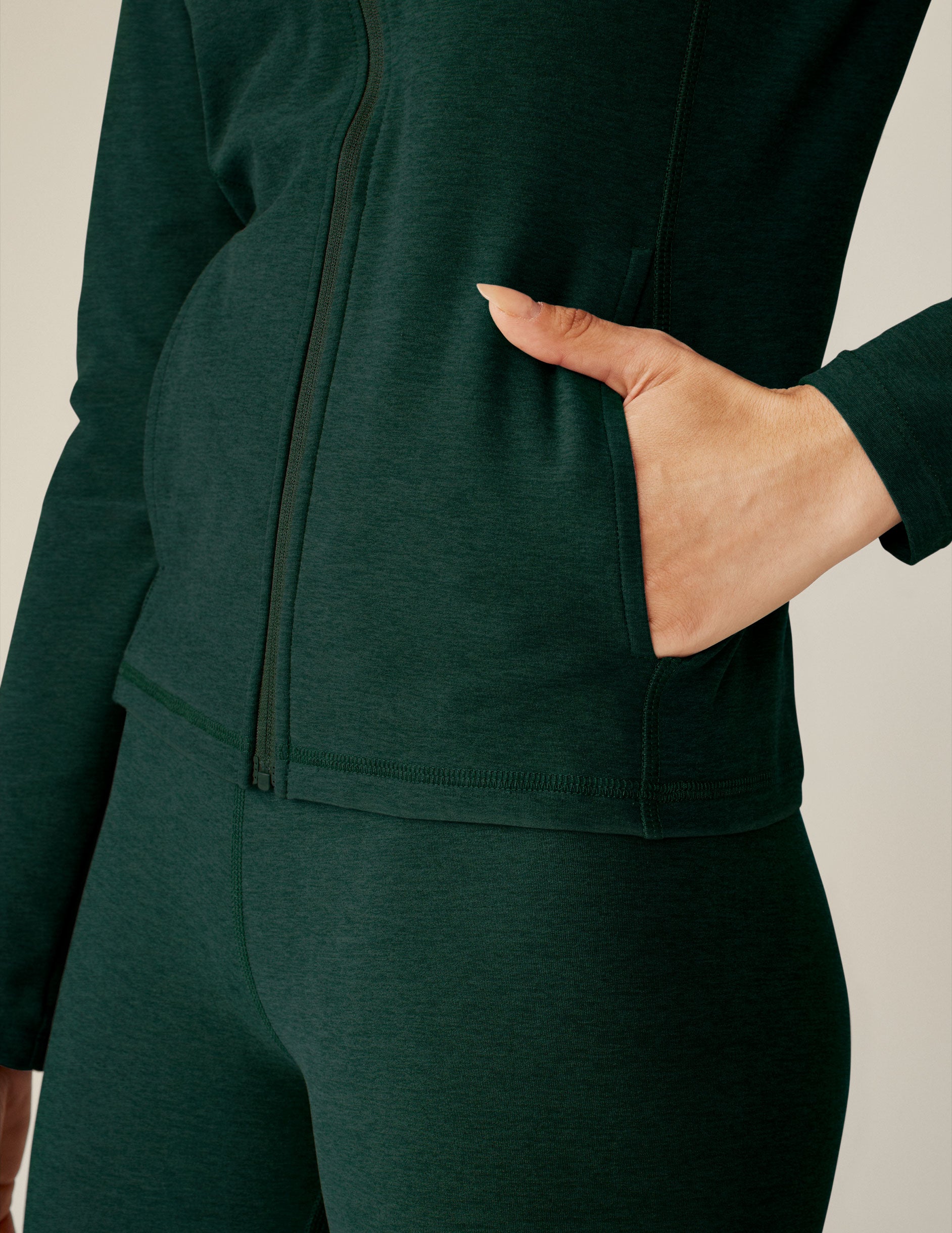 green zip-up mock neck jacket with side pockets. 