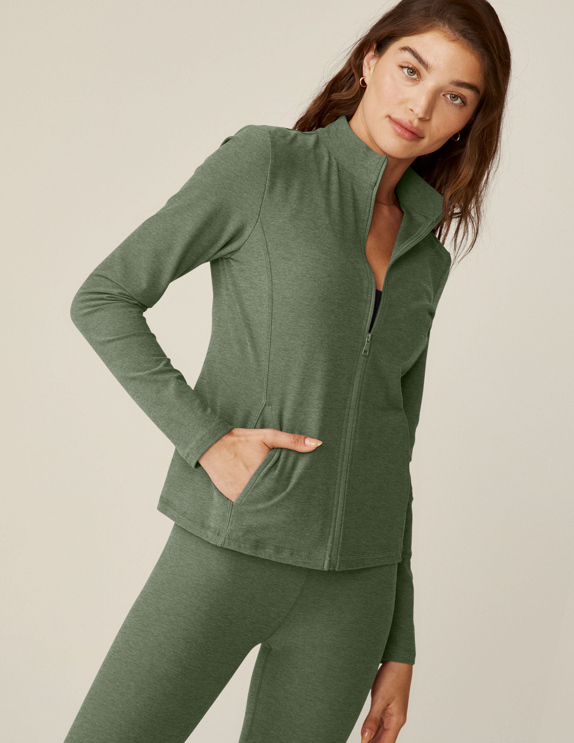 green mock-neck zip-up jacket with pockets.