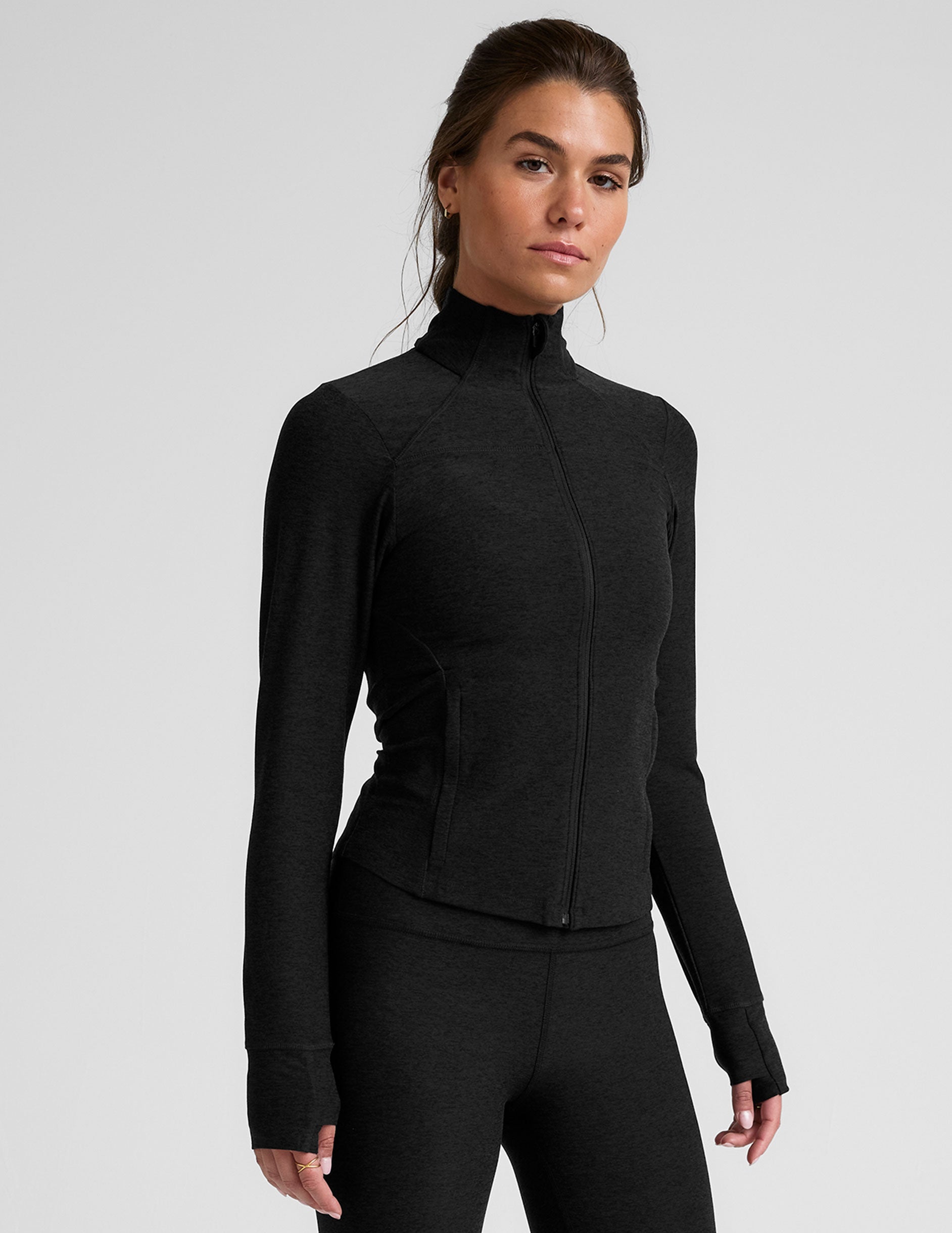 black zip-up mock neck jacket with pockets and thumbholes. 