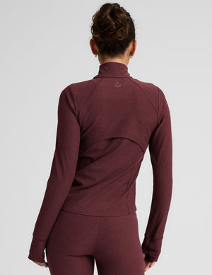 red zip-up mock neck jacket with pockets and thumbholes. 