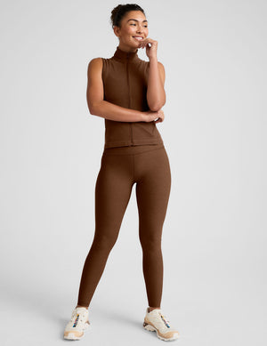brown zip-up vest with a mesh upper back detail and pockets. 