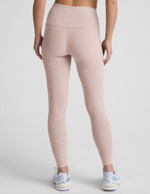 light pink high-waisted midi length leggings worn by model on a light gray background. 
