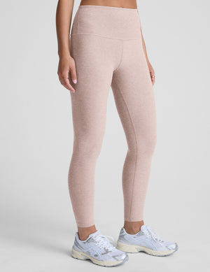 light pink high-waisted midi length leggings worn by model on a light gray background. 