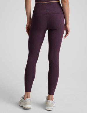 Woman wearing a purple athletic outfit on a gray background. 