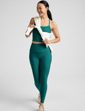 Woman wearing a green athletic outfit on a white background
