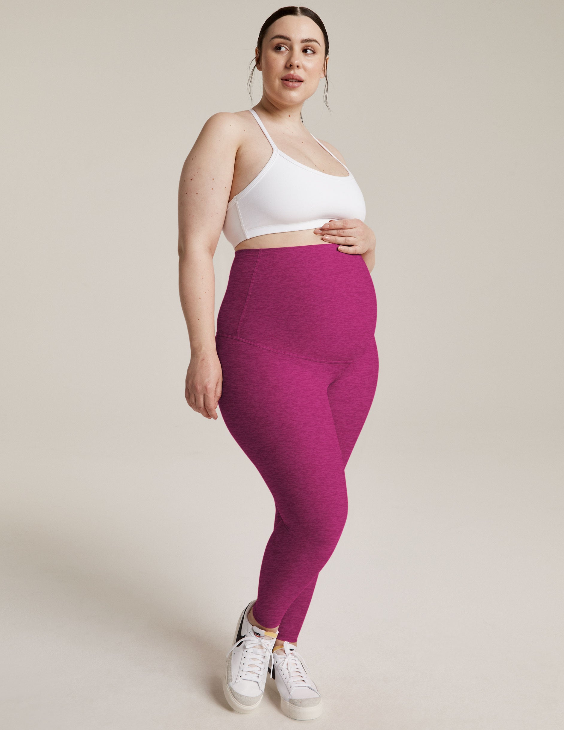 model is wearing purple maternity high-waisted midi leggings. 