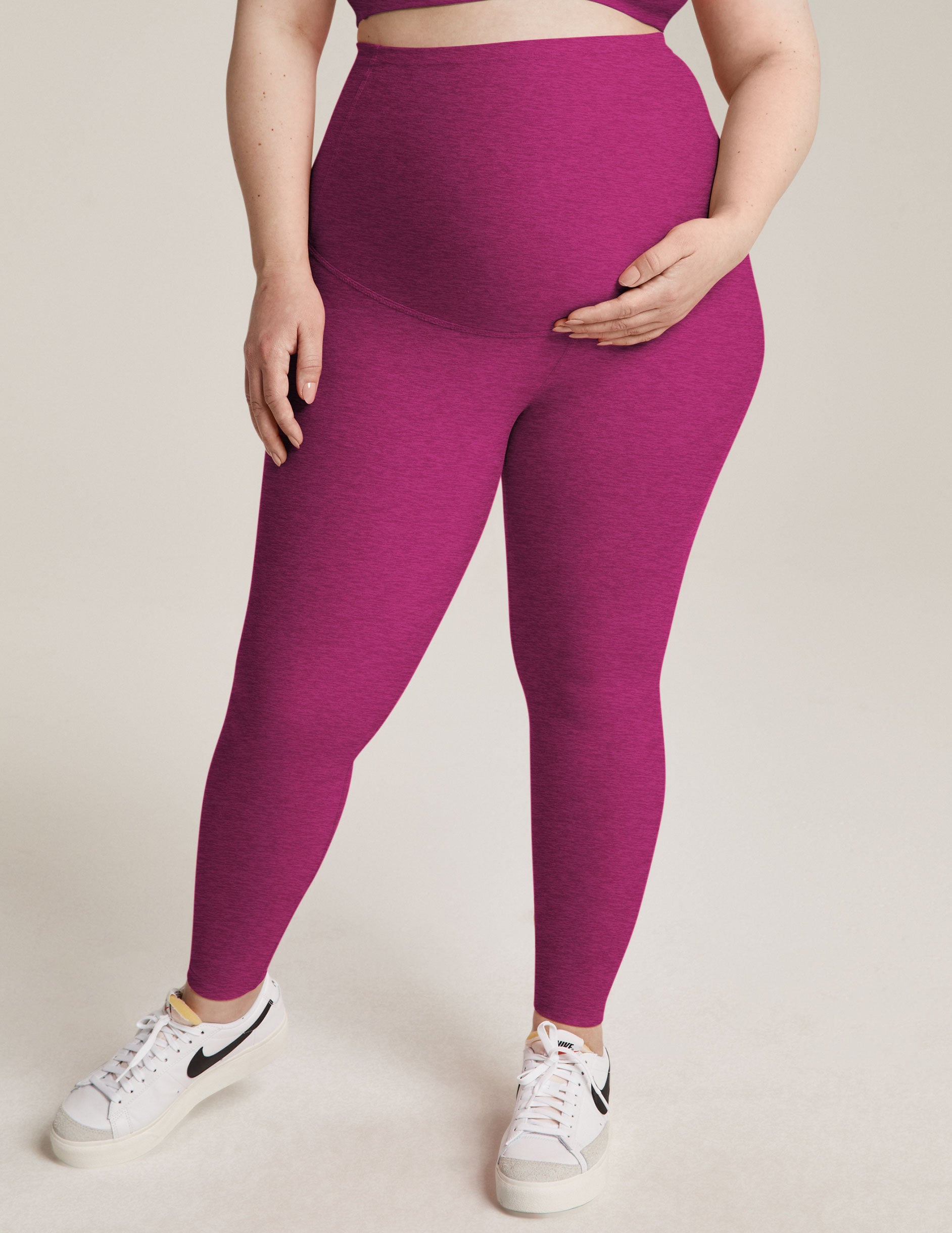 model is wearing purple maternity high-waisted midi leggings. 