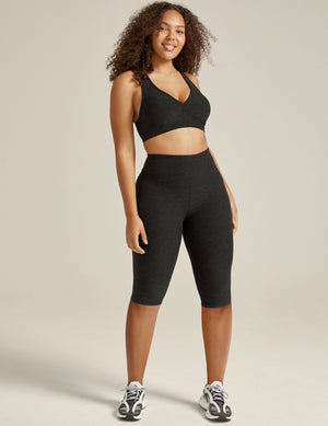 Woman in dark gray Spacedye Pedal Pusher High Waisted Legging, featuring a marled texture and high-rise, knee-length fit.