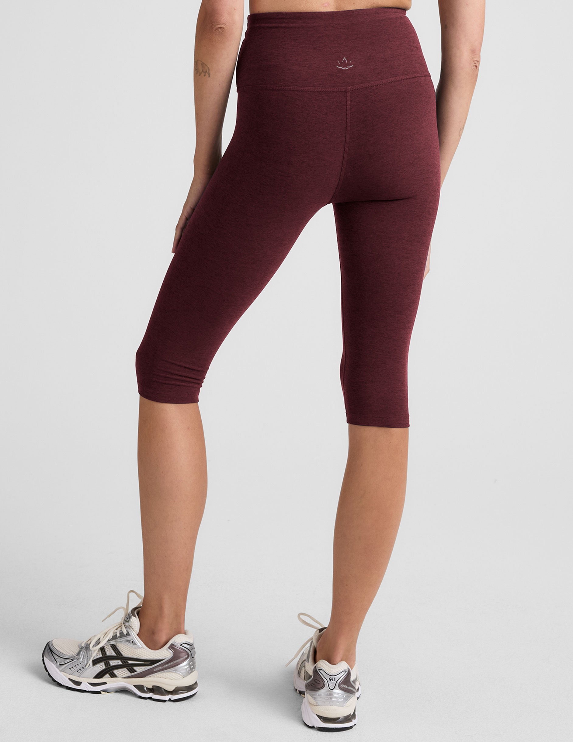 model is wearing red high-waisted pedal pusher length leggings. 