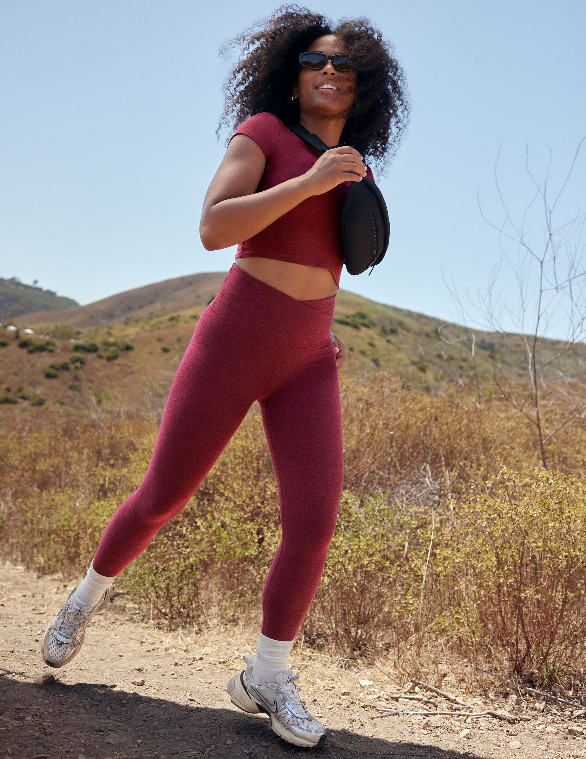 red high-waisted midi leggings with a crossover detail on the front waistband. 