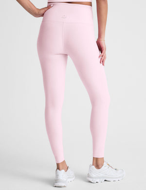 Pink leggings worn by a person on a light gray background