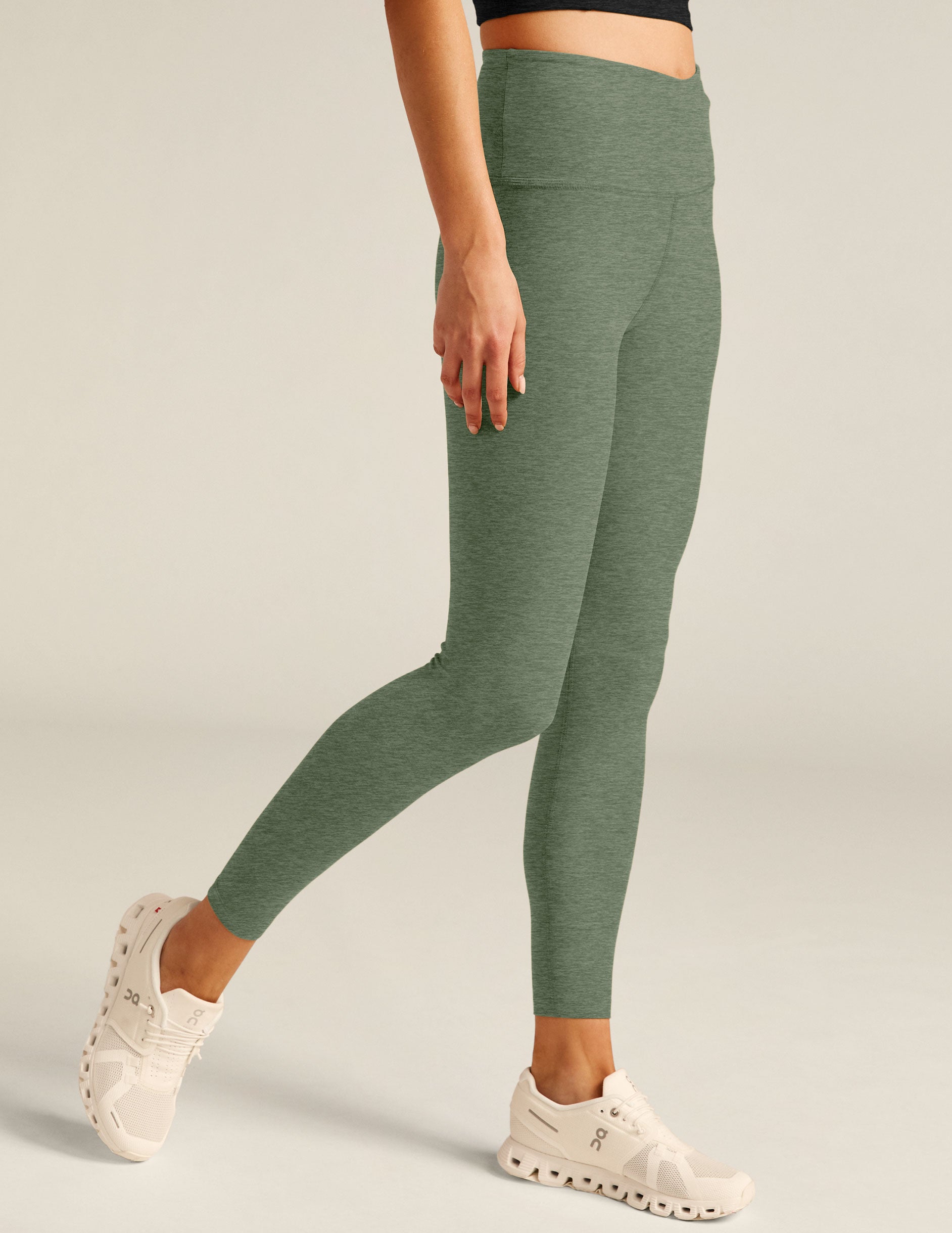 green high-waisted midi leggings with a crossover detail on the front waistband. 