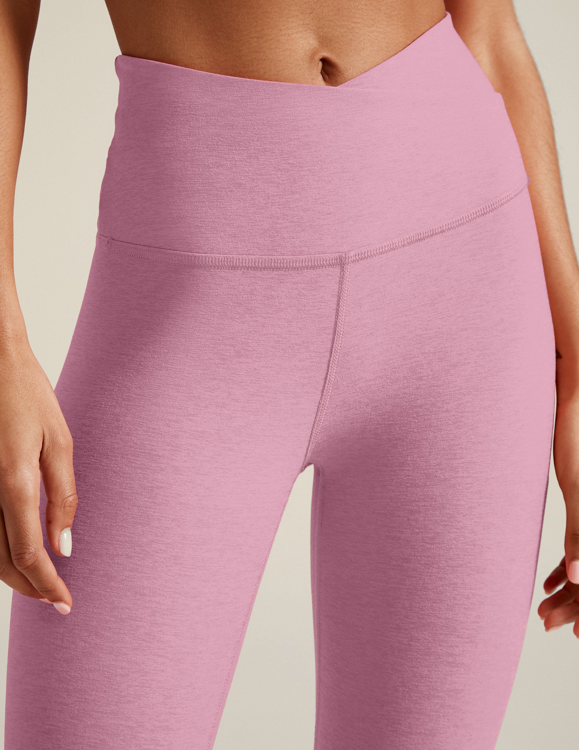 pink high-waisted midi leggings with a crossover detail on the front waistband. 