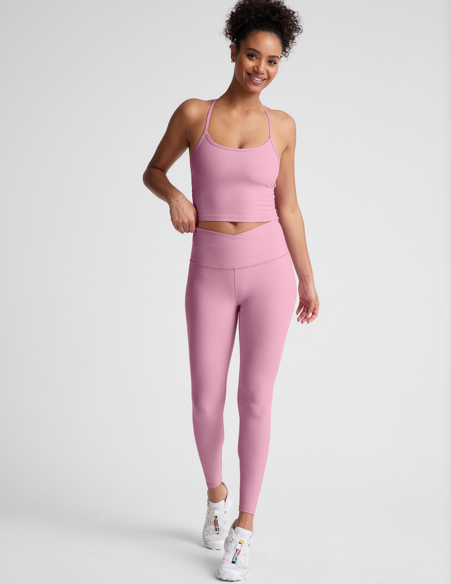 pink high-waisted midi leggings with a crossover detail on the front waistband. 