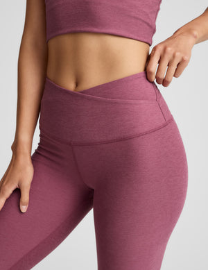 Person wearing mauve athletic leggings and top on a light gray background. 