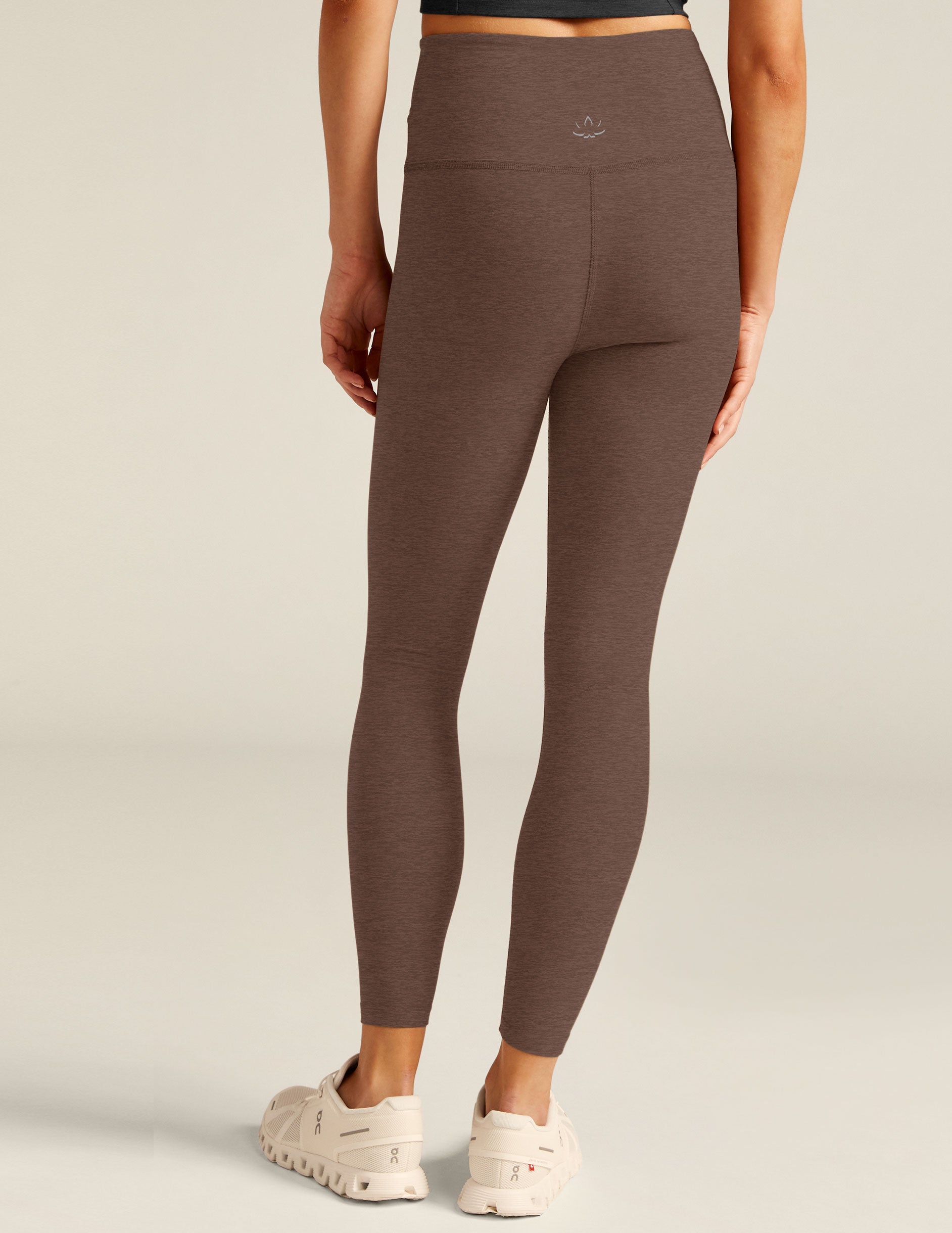 brown high-waisted midi leggings with a front crossover design on the waistband. 
