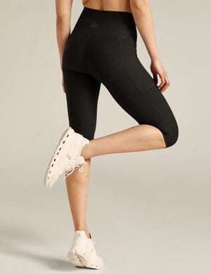 Rear view of black Spacedye High Waisted Pocket Pedal Pusher Legging showing the marled fabric, side pocket, and snug fit.