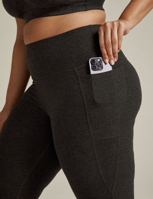 Spacedye Out Of Pocket High Waisted Capri Legging in marled dark gray with a phone tucked into the side hip pocket.