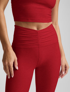 Woman wearing a red athletic outfit on a light gray background. 